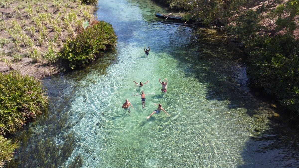 Groupe de personnes se baignant dans une rivière cristalline à Madagascar.