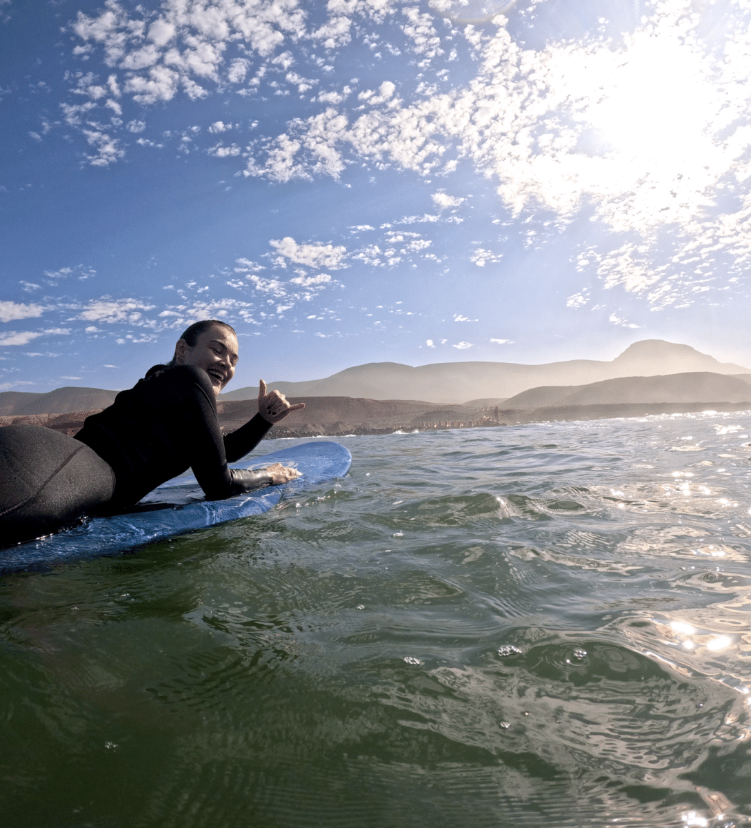 Surf enthusiast enjoying Moroccan waters with mountain views.