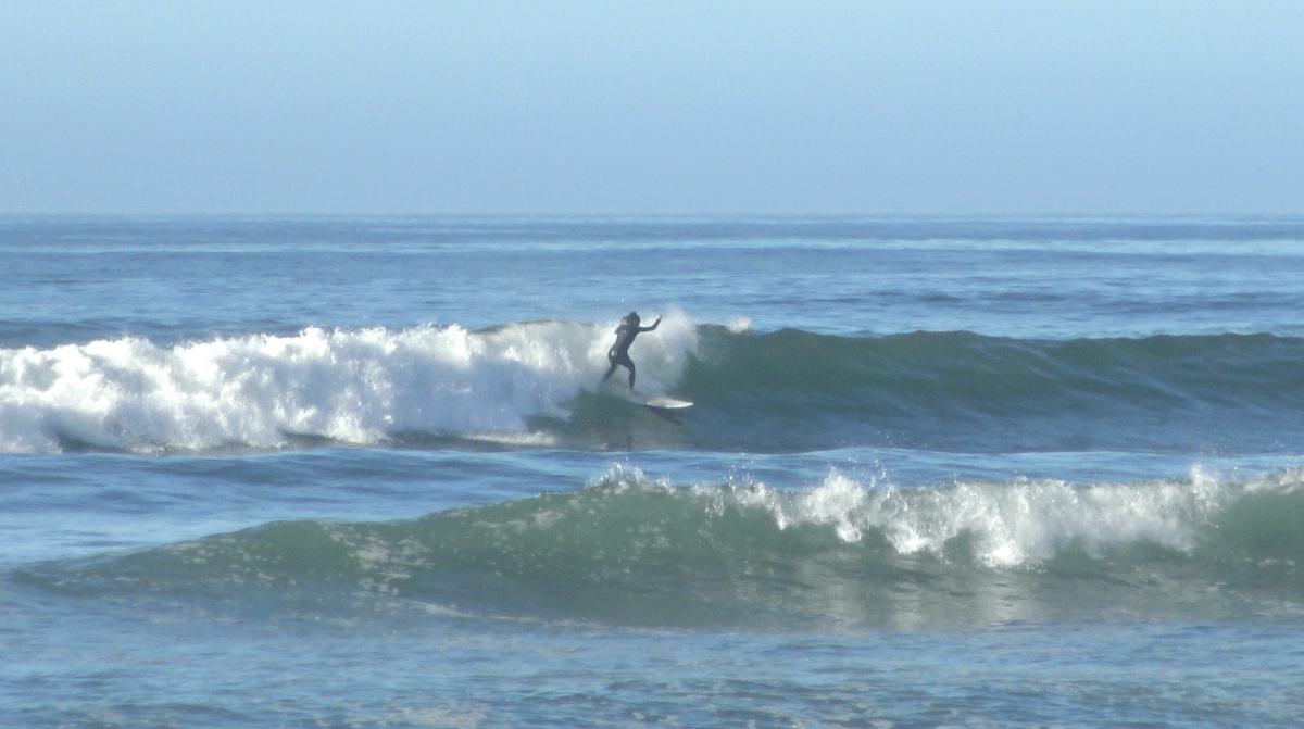 Surfer catching a wave on a surfboard in Morocco.