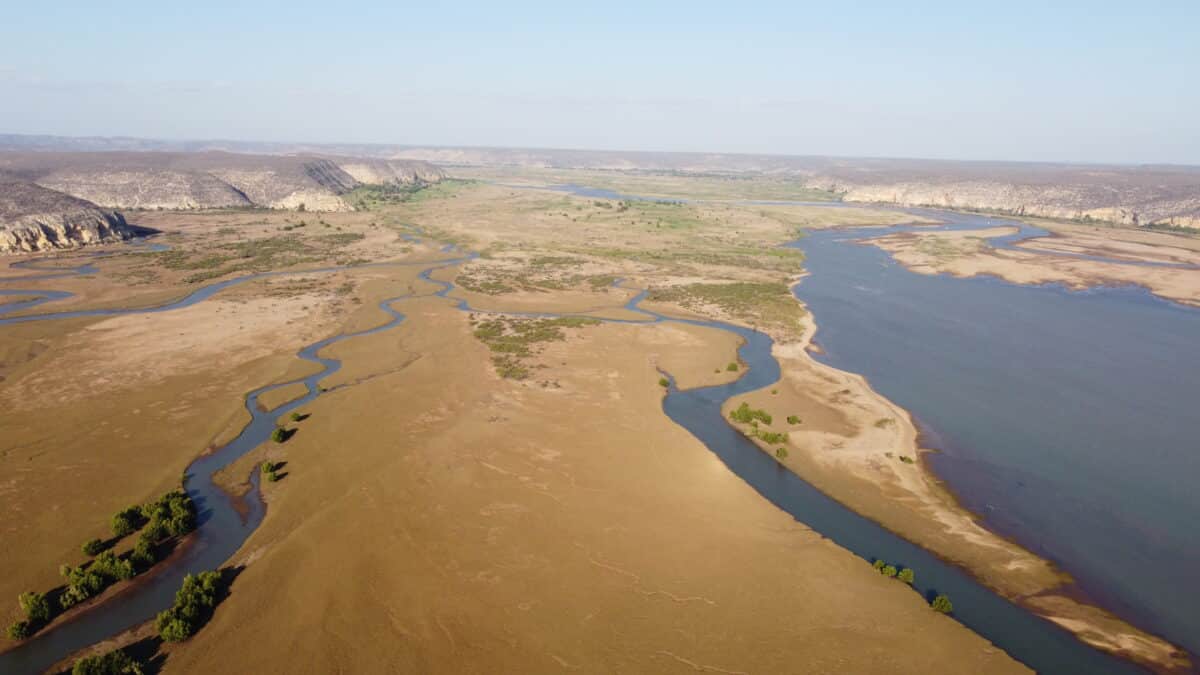 Vue aérienne d'un delta de rivière serpentant à travers le paysage sec de Madagascar.