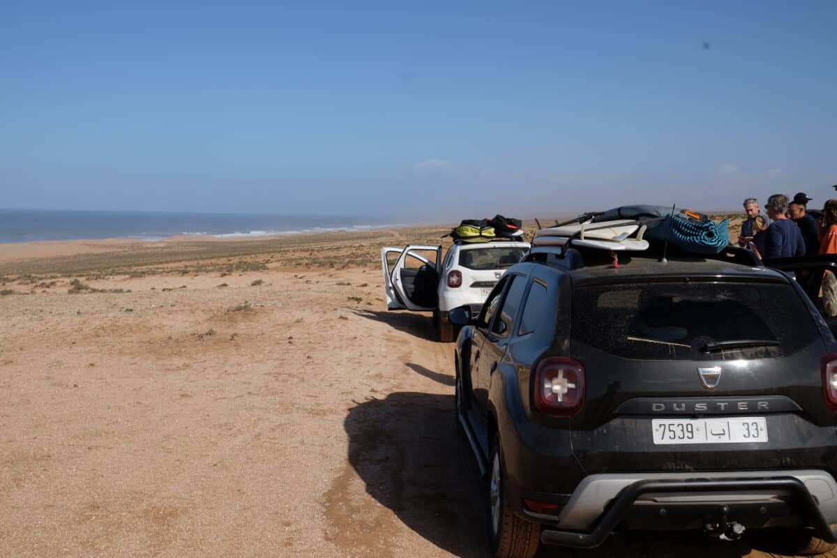 Convoi de voitures transportant des surfeurs vers les spots de surf au Maroc.