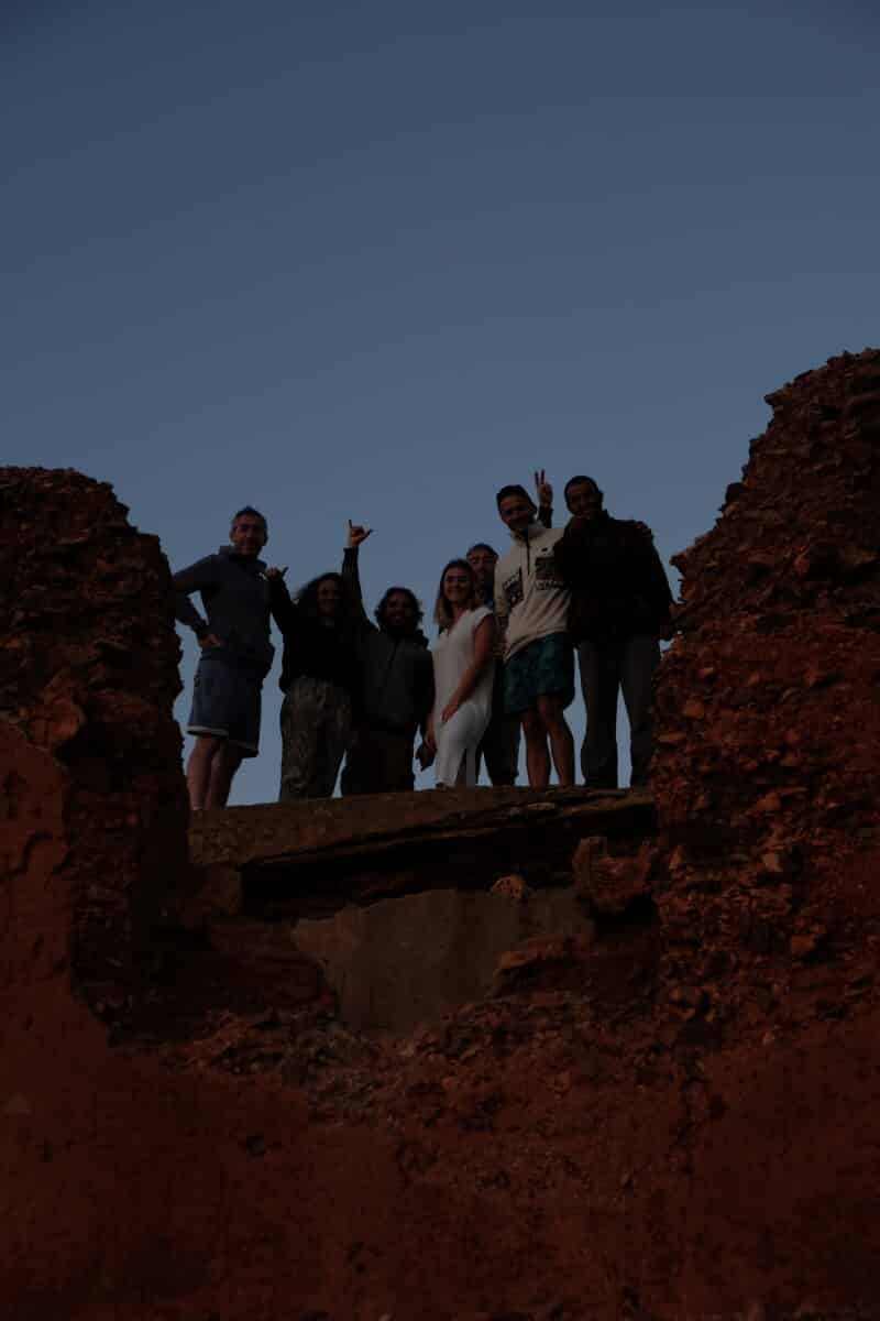 Groupe d'amis sur une plage marocaine au coucher du soleil.