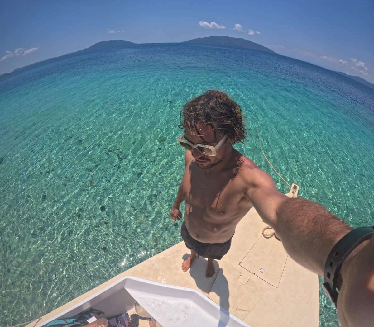 Un voyageur sur un bateau profitant des eaux cristallines et turquoises de Madagascar.