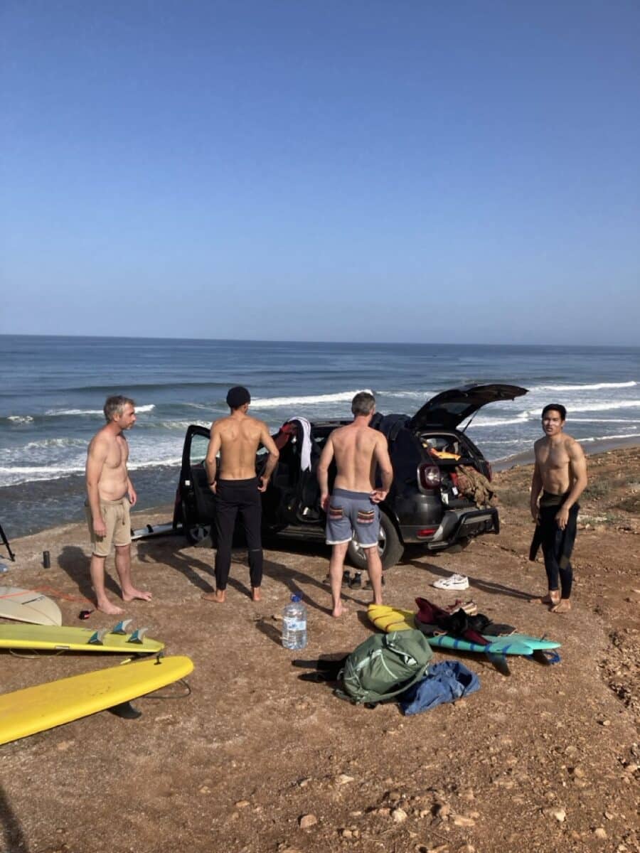 Surfeurs explorant le désert du sud marocain en quête de vagues.