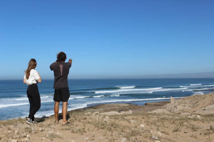 Deux personnes regardant l'océan depuis une falaise.