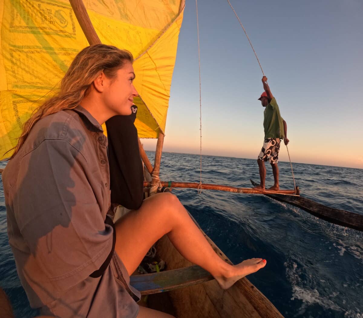 Voyageuse à bord d'une pirogue traditionnelle lors du coucher de soleil à Madagascar.