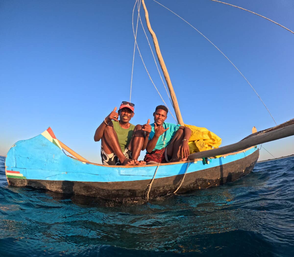 Deux pêcheurs malgaches à bord d'une pirogue traditionnelle sur la mer.