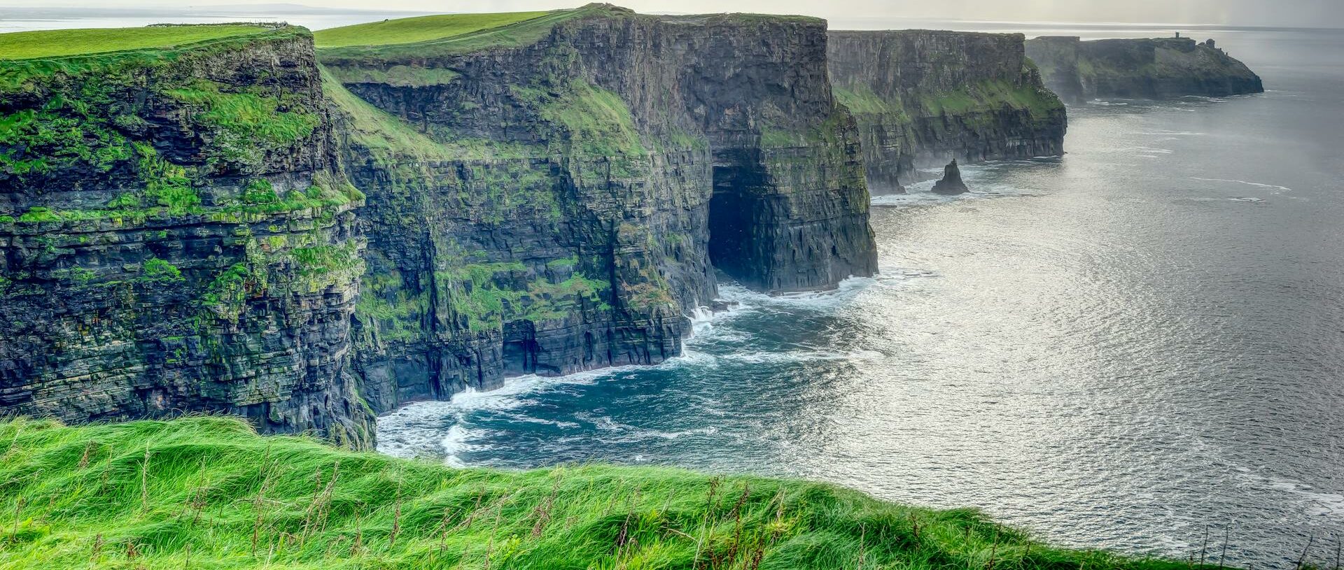 Les majestueuses Falaises de Moher en Irlande sous un ciel nuageux.