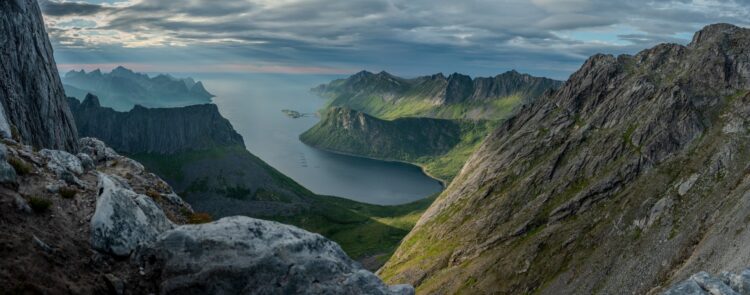 Paysage de fjords en Norvège avec montagnes abruptes et eau calme, idéal pour une croisière scénique.