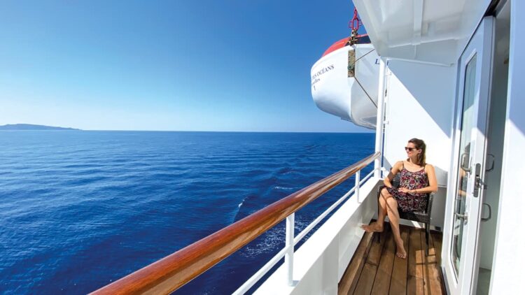 Passagère sur le balcon d'un bateau de croisière regardant l'océan.