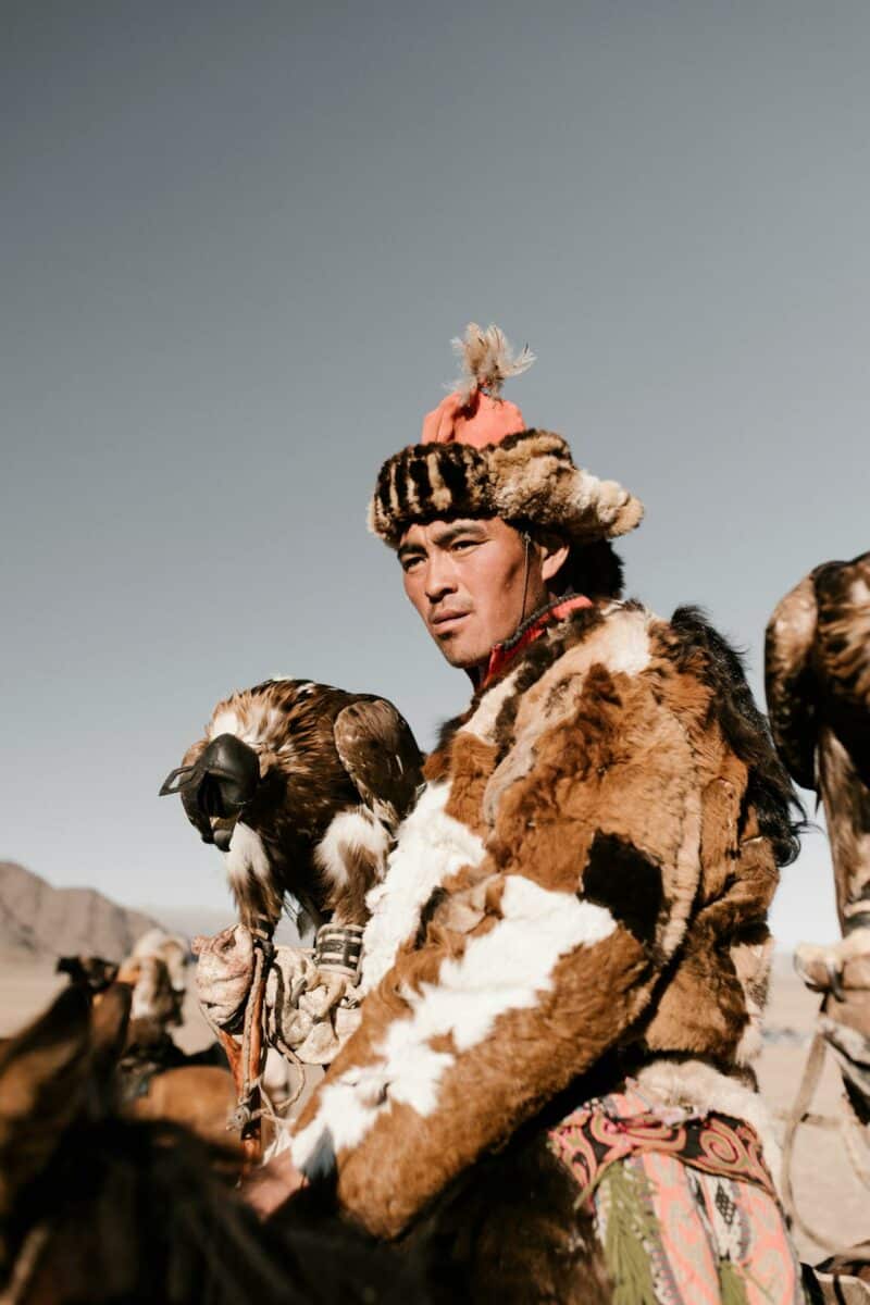 Chasseur d'aigles mongol avec son oiseau dans le désert