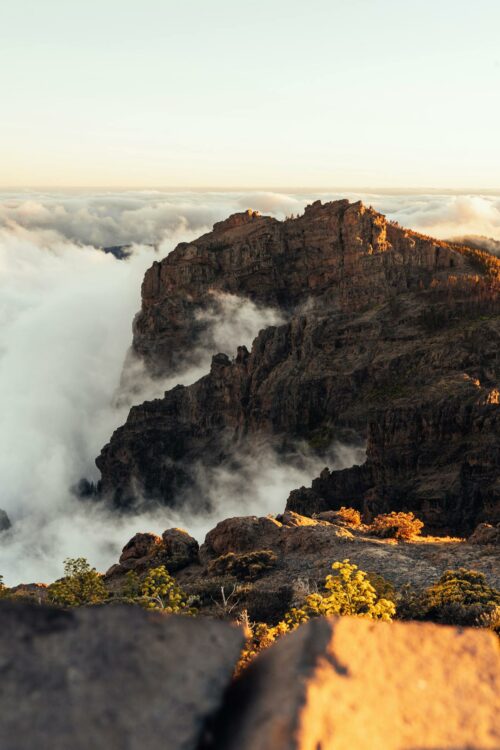 Vue stupéfiante d'un sommet montagneux émergeant au-dessus des nuages au coucher du soleil aux Îles Canaries.