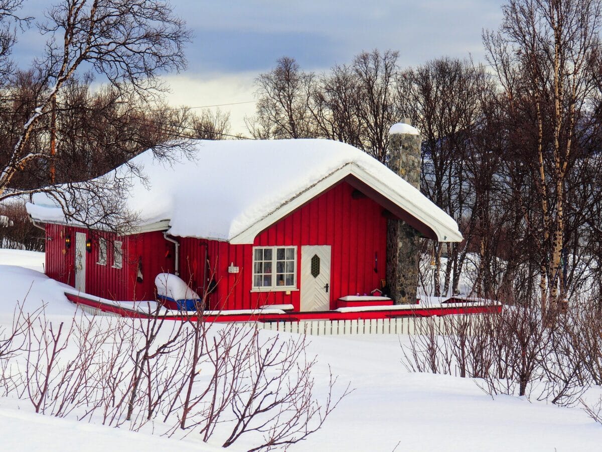 Cabane rouge dans la forêt enneigée de Laponie