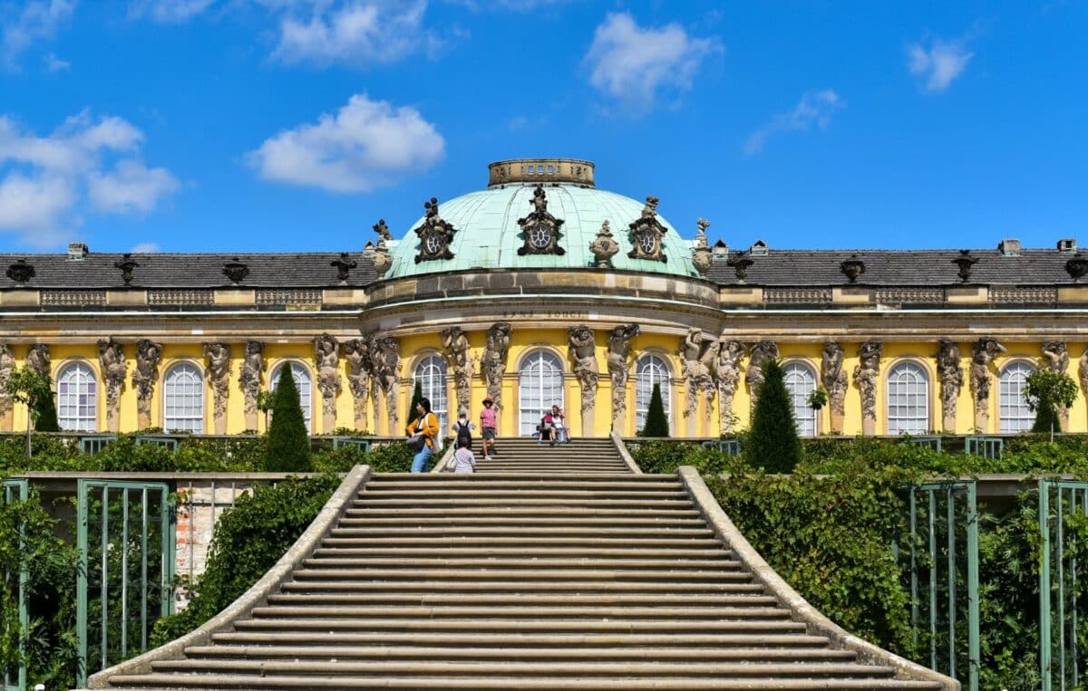 Escaliers menant au château Sanssouci de Potsdam, sous un ciel bleu.