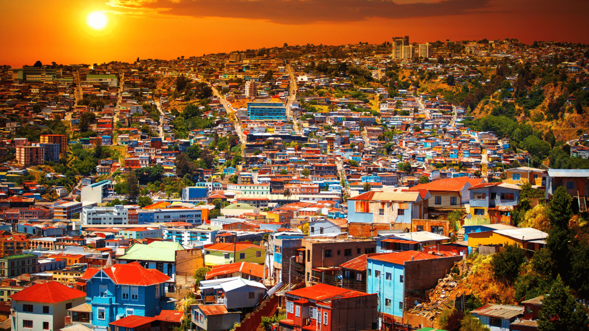 Coucher de soleil sur Valparaíso avec vue panoramique sur les collines et les maisons colorées.