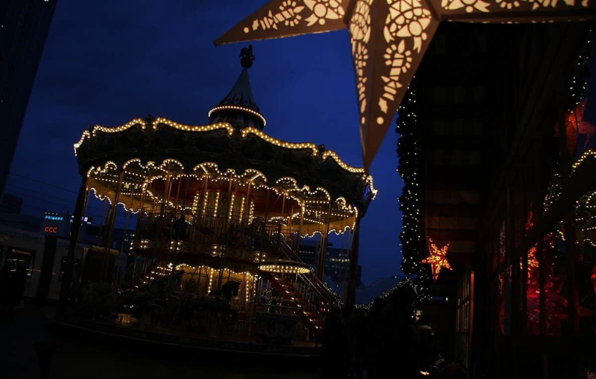 Marché de Noël féerique à Berlin avec tentes illuminées et la cathédrale en arrière-plan.