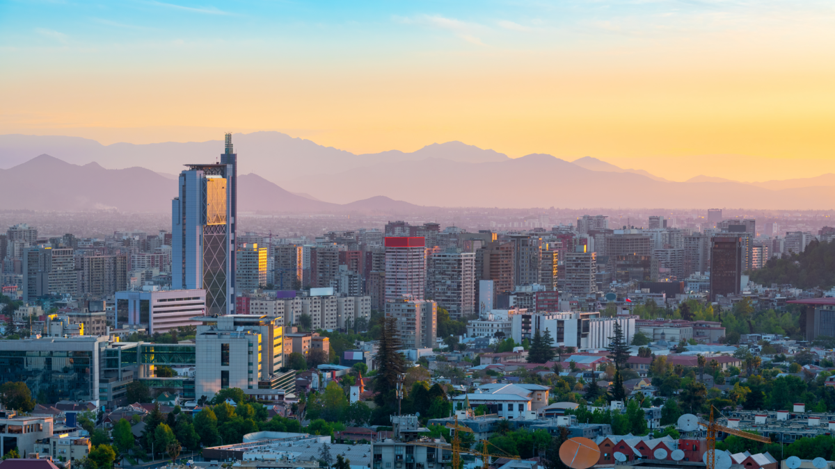 Panorama urbain de Santiago au coucher du soleil avec vue sur les montagnes andines.