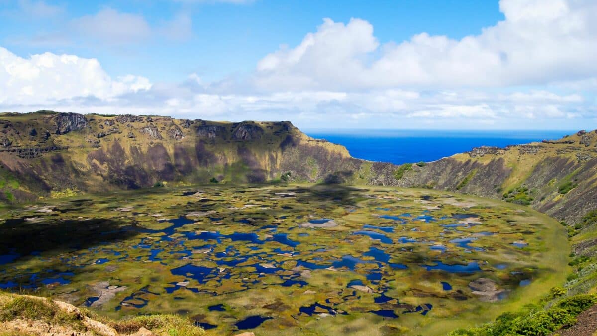 Superbe lac de cratère au sommet du volcan Rano Kau sur l'Île de Pâques avec l'océan en arrière-plan.