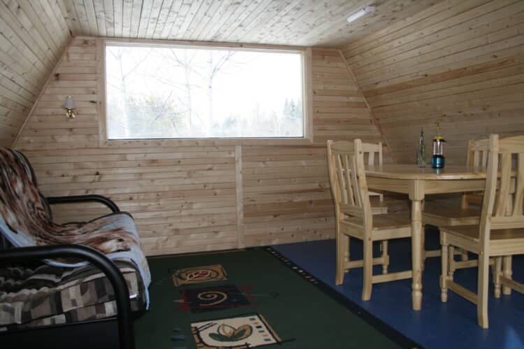 Intérieur chaleureux d'une cabane en bois avec espace de vie confortable au Canada.