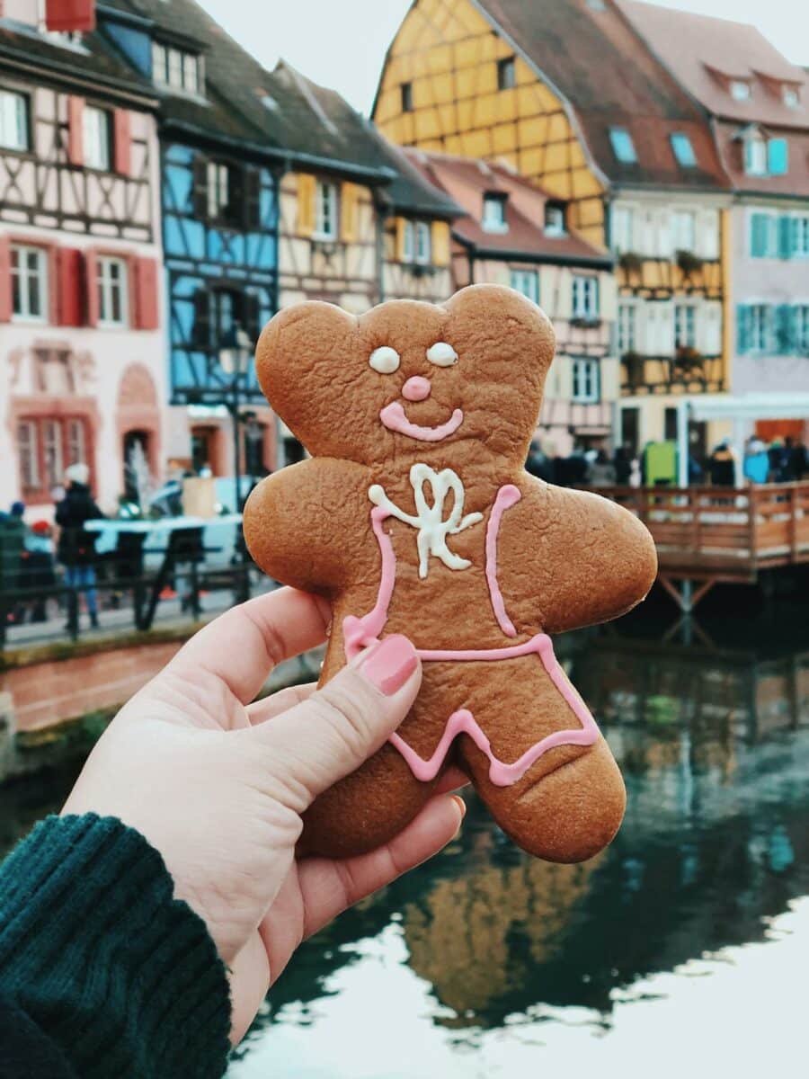 Biscuit pain d'épice décoré en forme de bonhomme, devant maisons alsaciennes.