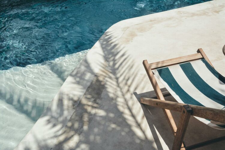 Piscine avec chaises longues et ombre des palmiers à Bali