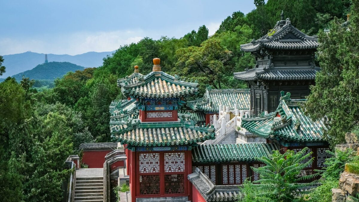 Vue panoramique du Palais d'été à Pékin entouré de forêts et montagnes.