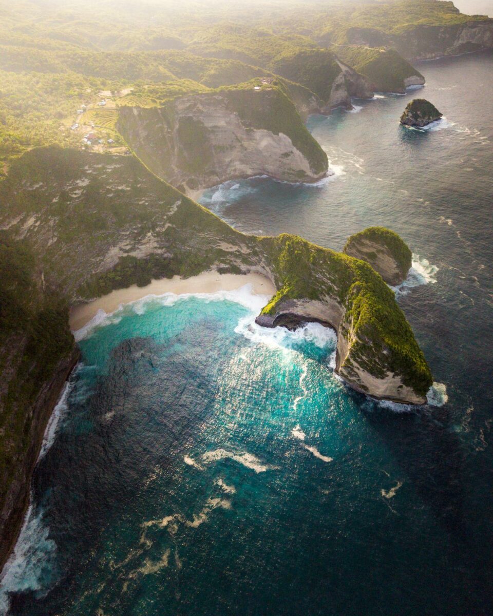 Vue aérienne spectaculaire des falaises de Nusa Penida avec une plage cachée au creux des falaises à Bali.