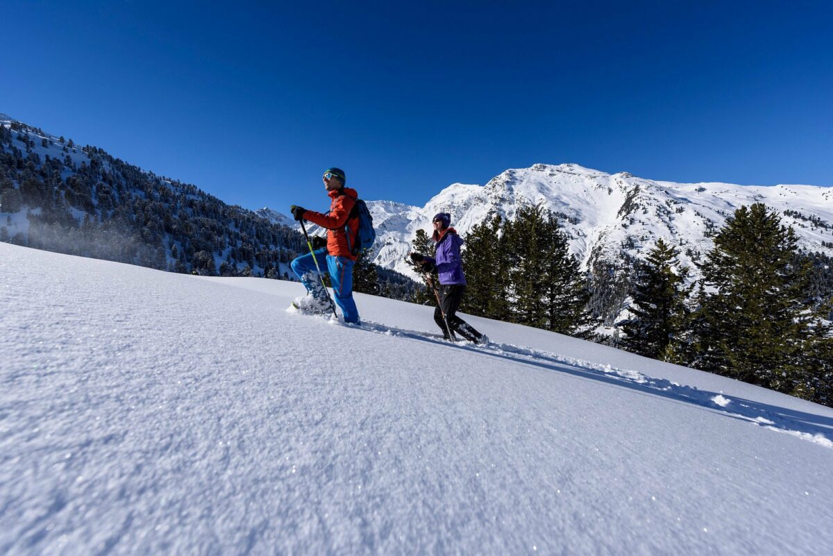 Deux personnes pratiquant la randonnée en raquettes dans les montagnes enneigées du Tyrol