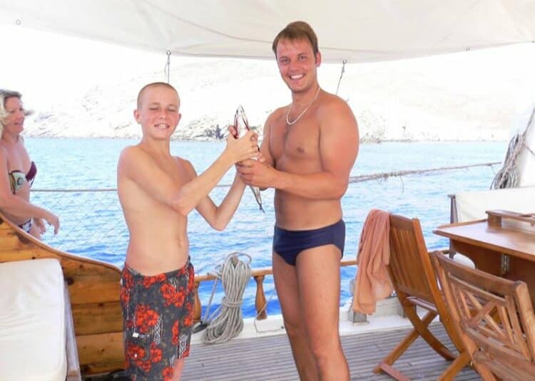 Invités célébrant une belle prise de pêche sur le pont d'un yacht de luxe en Grèce