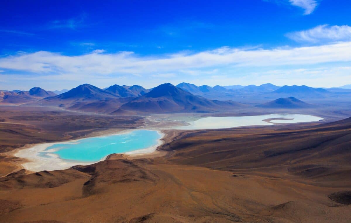 Vue aérienne de lacs colorés dans un paysage désertique de haute altitude.