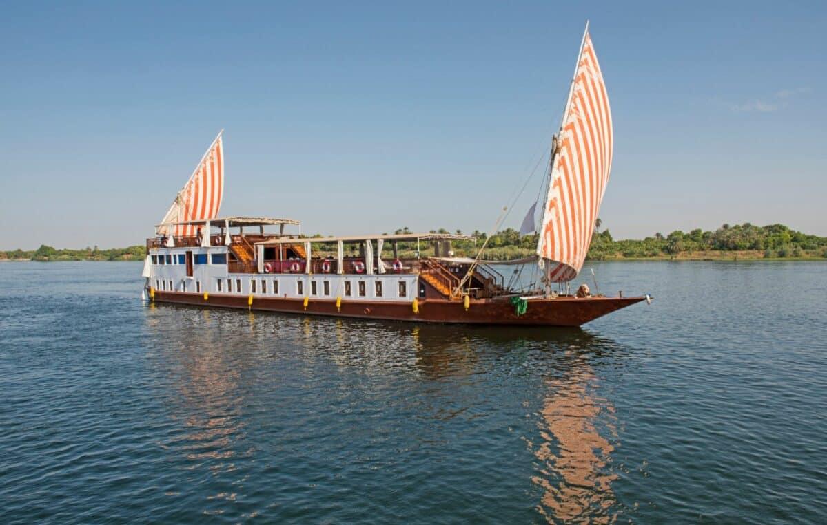 Bateau Dahabeya à double voile naviguant sur le Nil en Égypte.