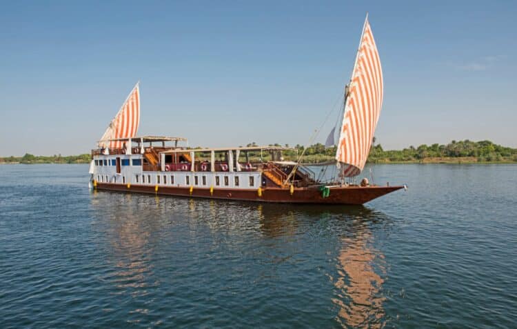 Bateau Dahabeya à double voile naviguant sur le Nil en Égypte.