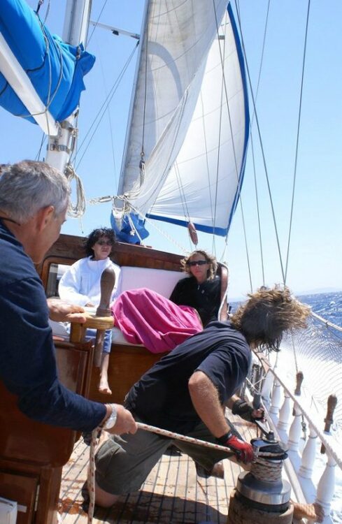 Équipage et invités ajustant les voiles lors d'une croisière en yacht de luxe en mer Égée