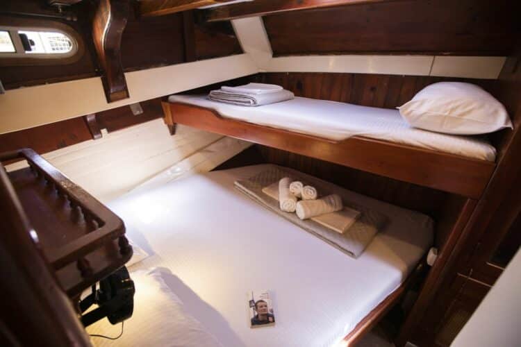 Cabine en bois chaleureuse avec lits superposés et literie fraîche sur un yacht de luxe