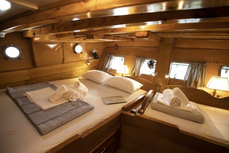 Cabine principale spacieuse sur un yacht de luxe, avec un grand lit et un décor en bois élégant