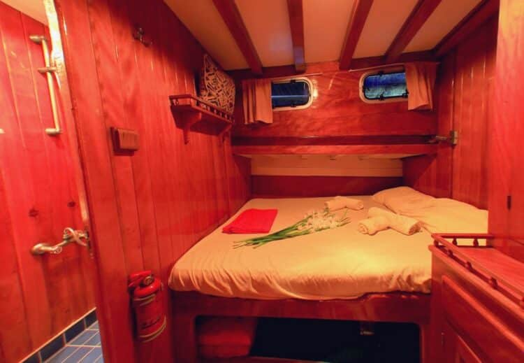 Cabine double avec lit en bois sur un voilier pour croisière