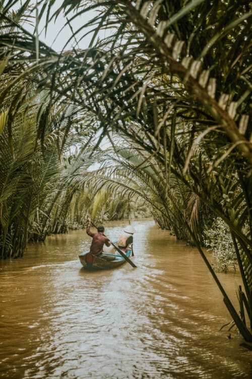 Canal de Chao Gao traversé par un bateau traditionnel sous les palmiers.