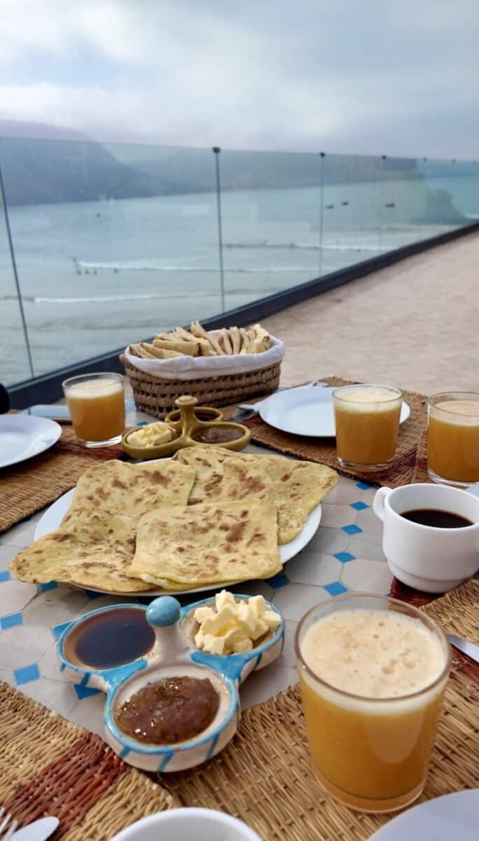 Petit-déjeuner marocain traditionnel avec vue sur l’océan.