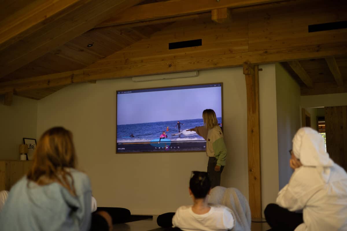 Coline Ménard animant un workshop de surf avec analyse vidéo.