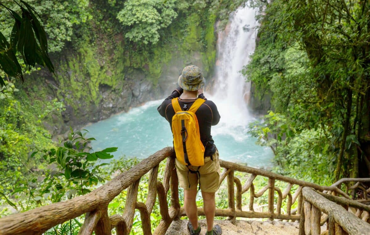 Touriste admirant une cascade en pleine forêt tropicale