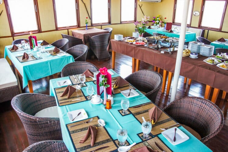 Salle de restaurant élégante à bord du bateau RV Toum Tiou II, avec des tables dressées pour un service de qualité.