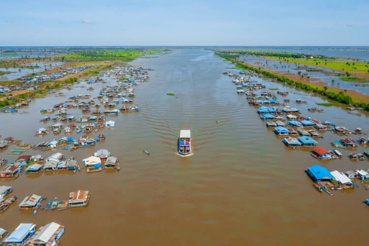 Vue aérienne du fleuve Mékong et des villages flottants au Cambodge, avec une croisière au centre.