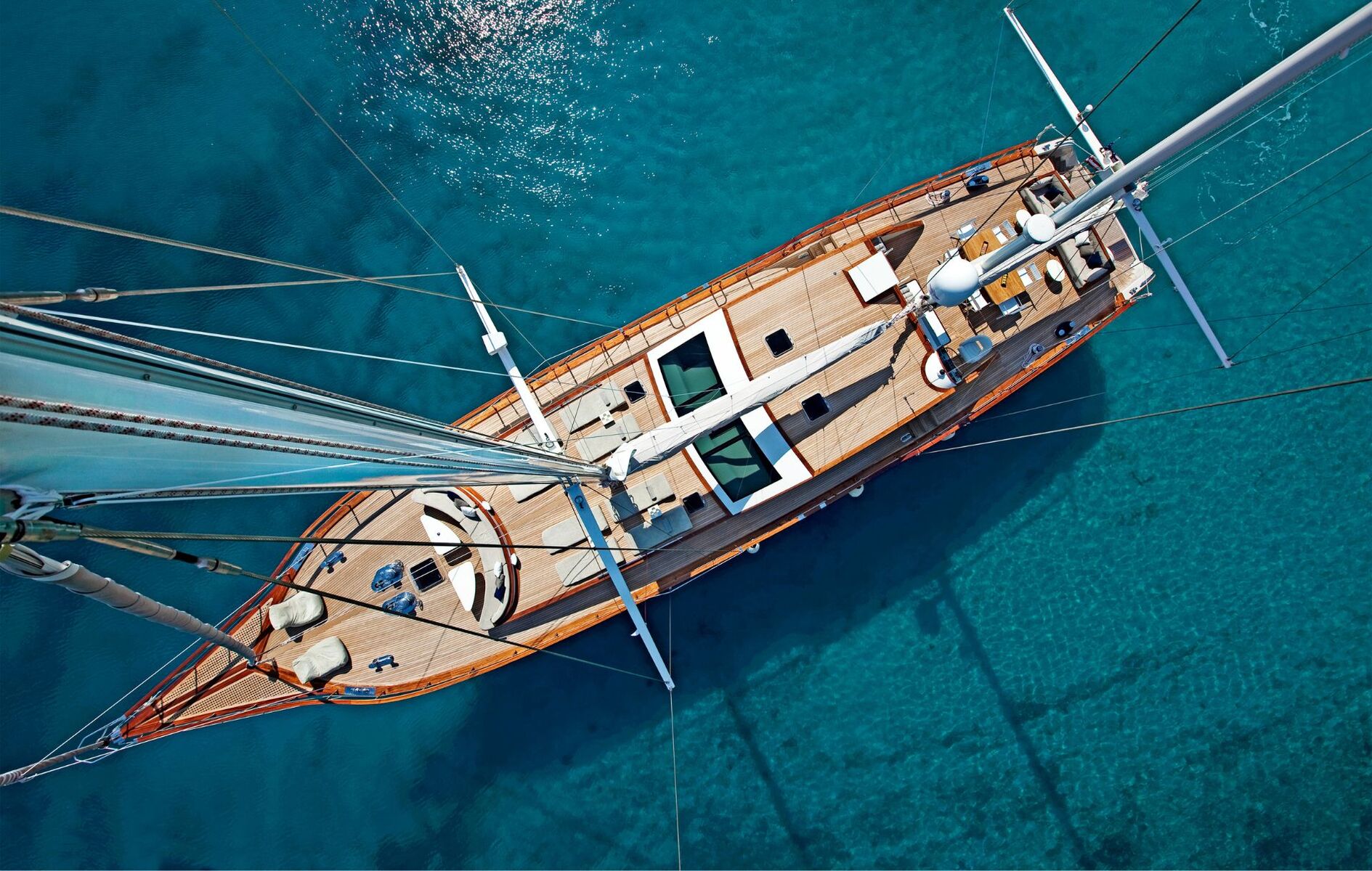 Vue aérienne d'un voilier traditionnel en bois sur une eau turquoise lors d'une croisière en petit bateau en Grèce