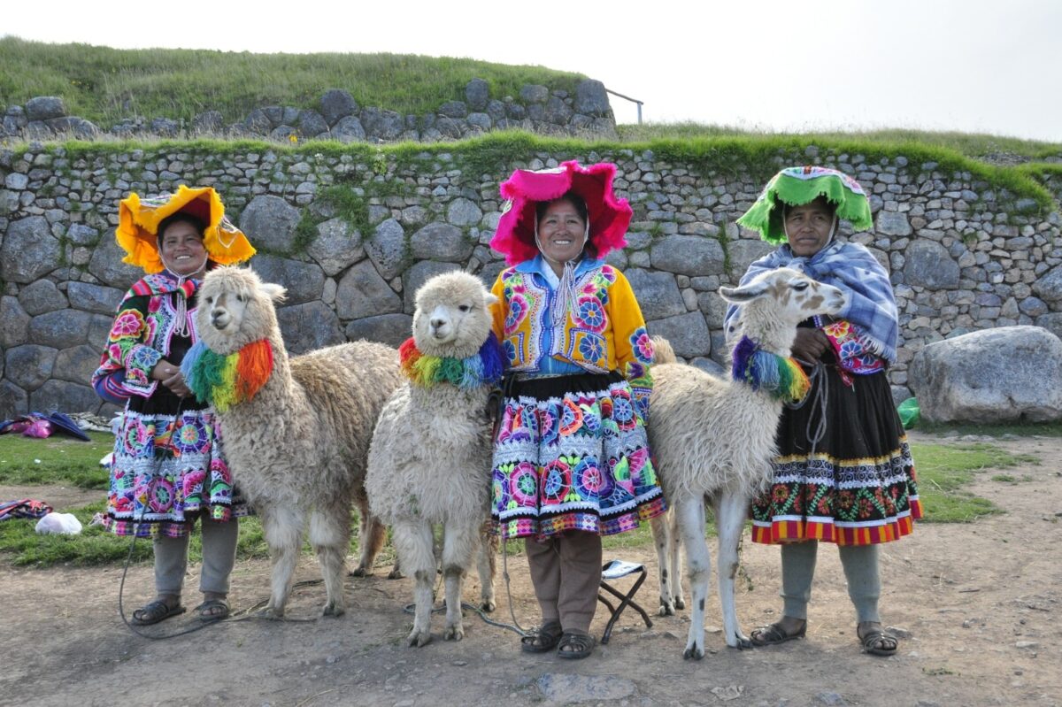 Femmes Quechua en costumes traditionnels avec des lamas dans la Vallée Sacrée.