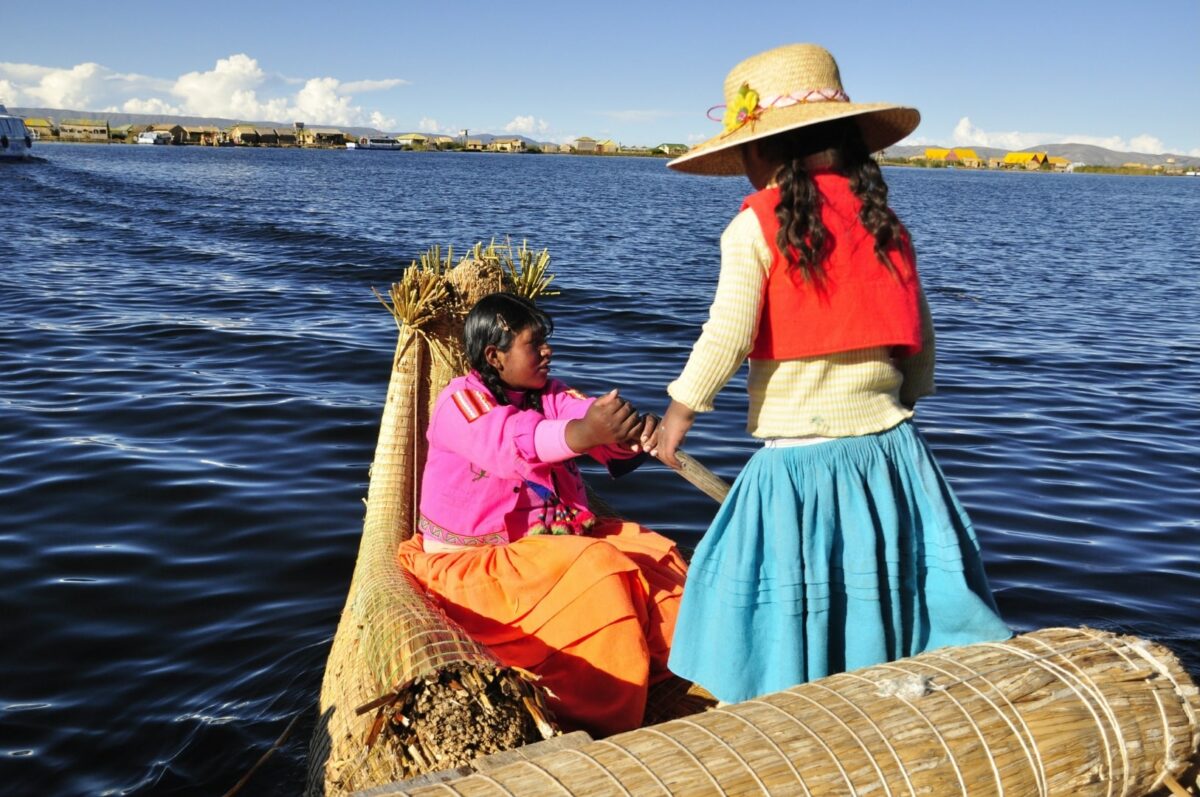 Deux femmes Uros naviguant sur une pirogue traditionnelle en roseaux sur le Lac Titicaca.