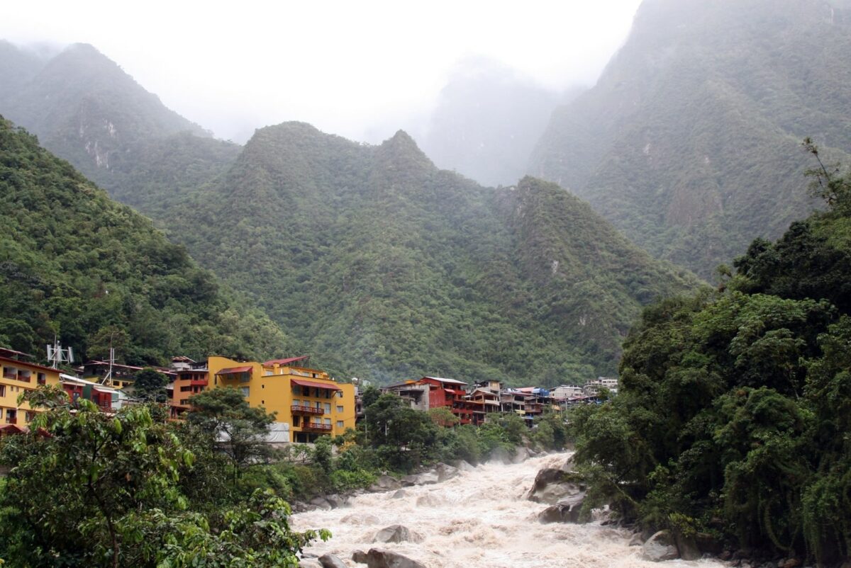 Vue du village d'Aguas Calientes, entouré par une végétation luxuriante et des montagnes brumeuses.