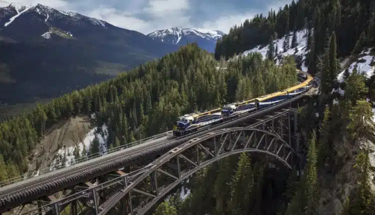 Le Rocky Mountaineer traversant le pont de Stoney Creek, entouré de montagnes et de forêts majestueuses.