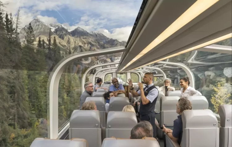 Passagers profitant de la vue panoramique depuis le wagon vitré du Rocky Mountaineer à travers les Rocheuses canadiennes.