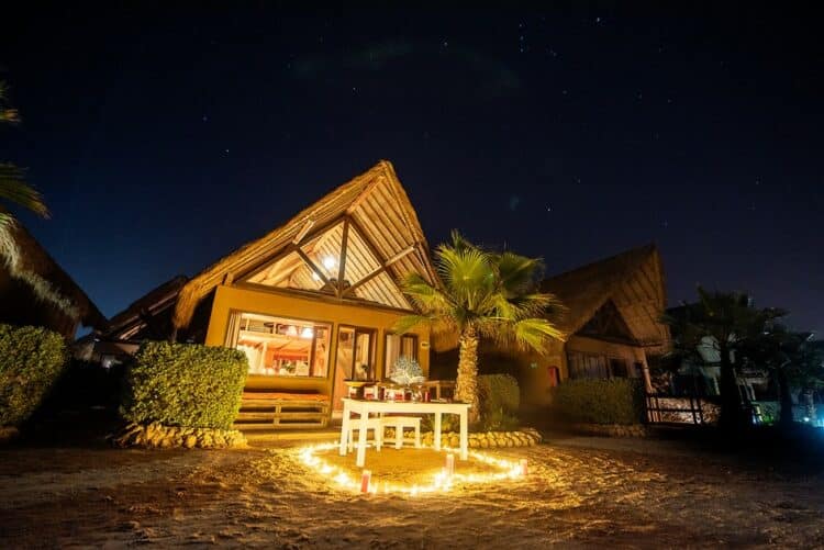 Cadre romantique illuminé par des bougies devant un bungalow à West Point Dakhla.